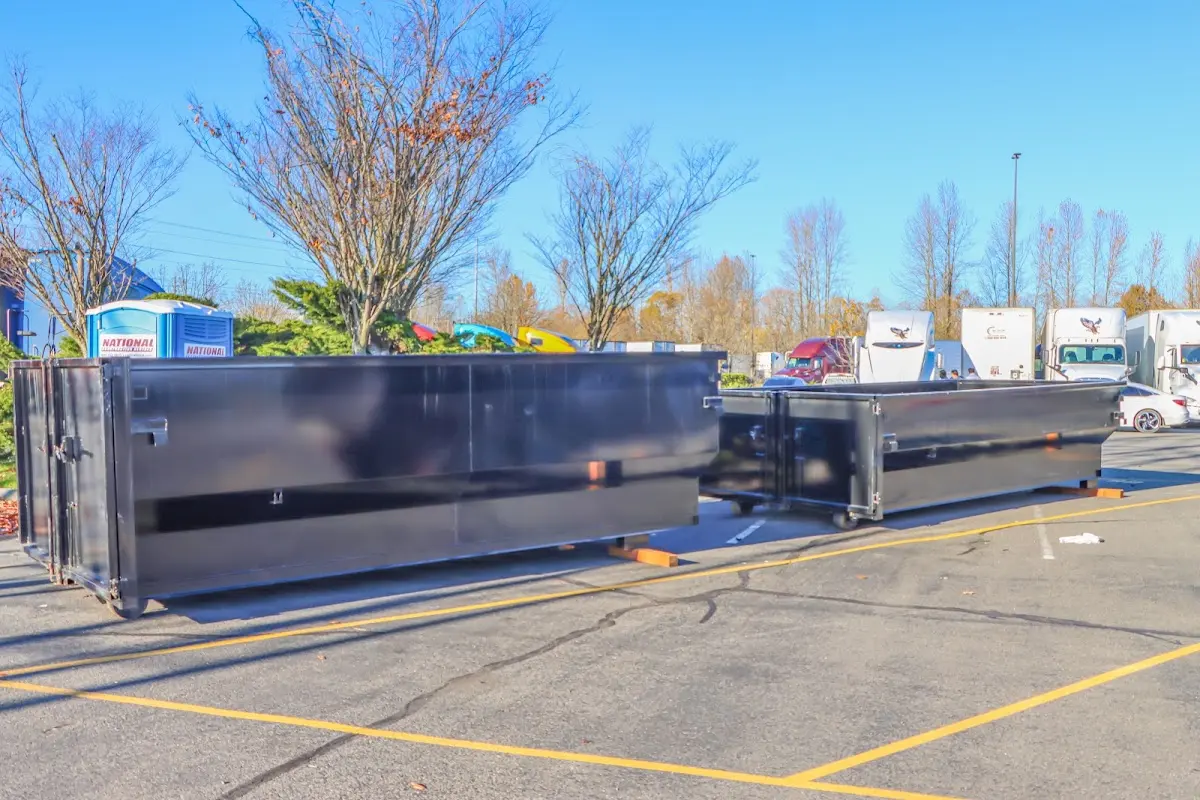 Professional dumpster rental service with roll-off container on residential driveway in Peabody